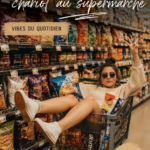 Femme poussant un caddie plein de courses au supermarché, souriante.