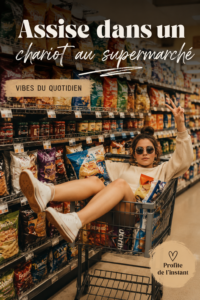 Femme poussant un caddie plein de courses au supermarché, souriante.